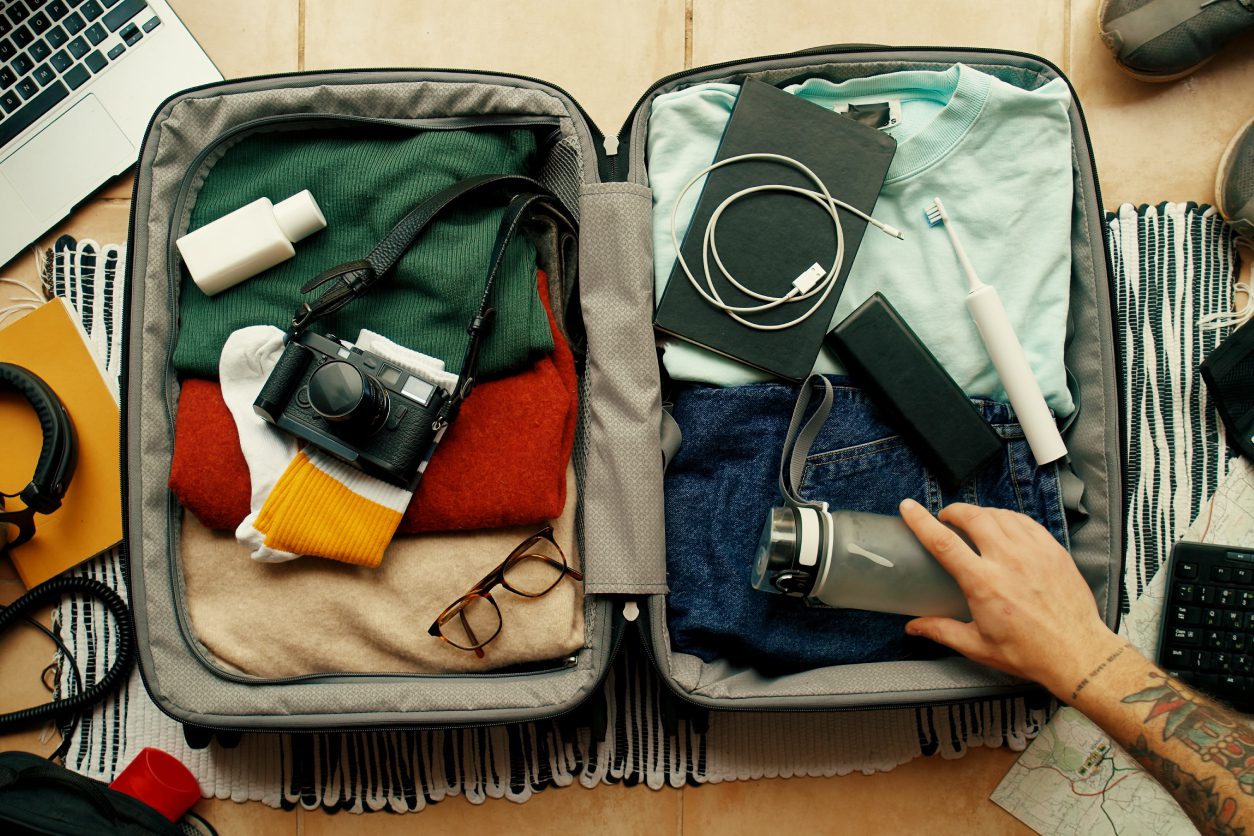 Open suitcase with clothes and travel essentials.