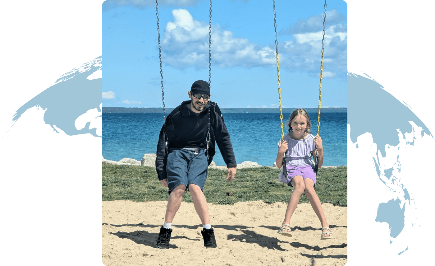 A man and a girl swinging together on a sunny beach day.