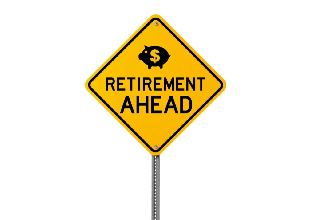 Yellow road sign with a piggy bank and 'Retirement Ahead' text.